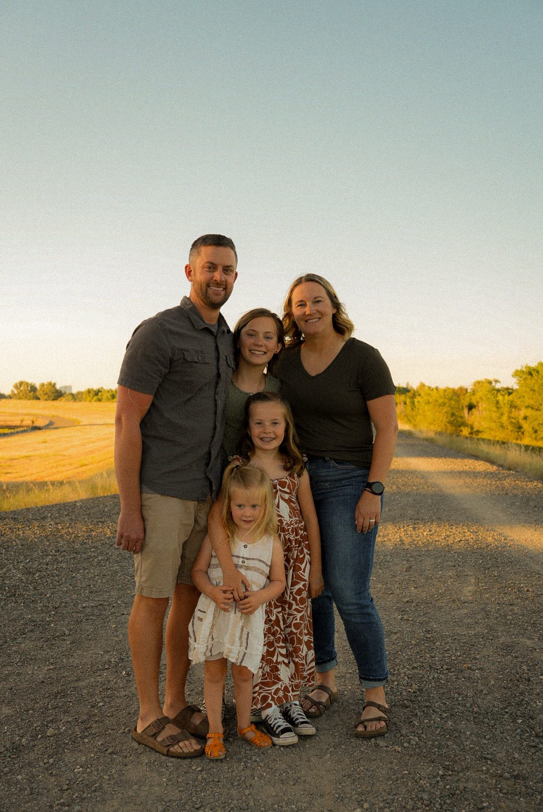 Family of five walking down a golden-hour path