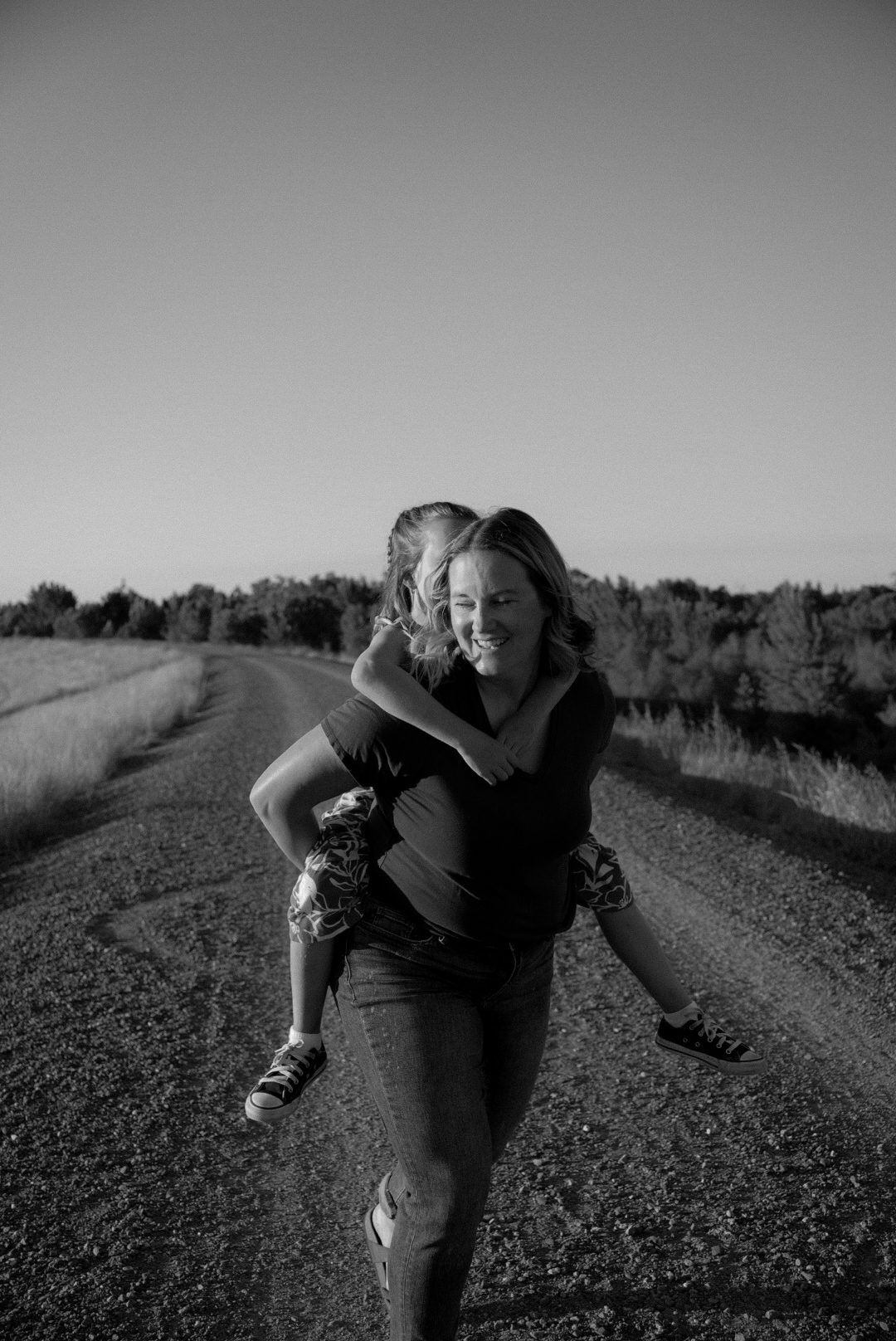 Black-and-white portrait of a mom carrying her son