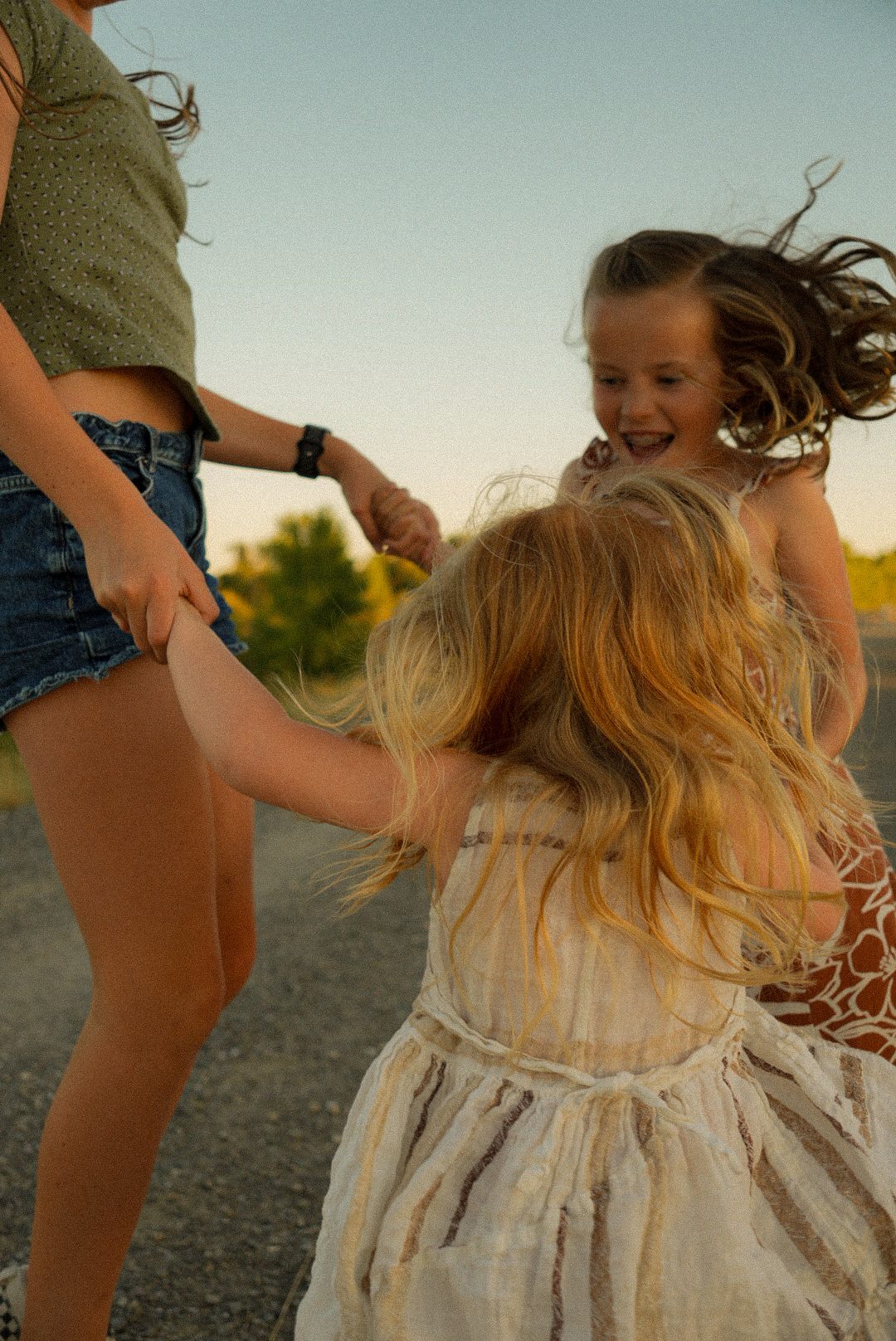 Sisters dancing together in a field