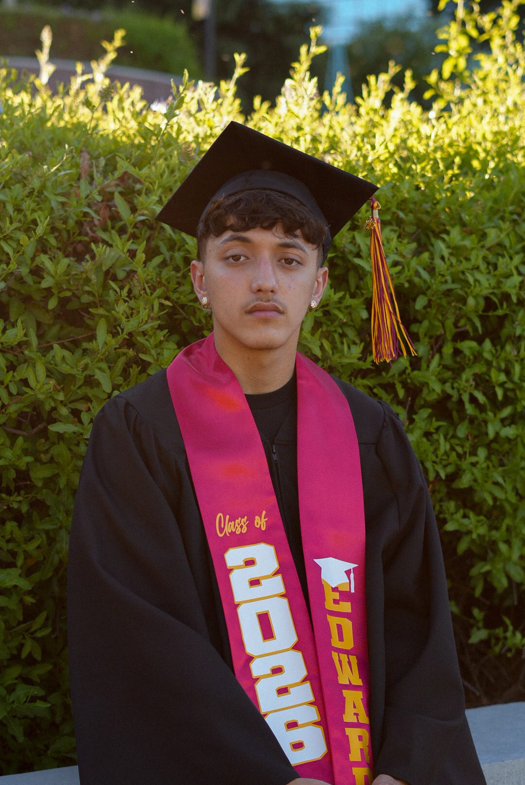 Senior portrait in cap and gown, golden hour